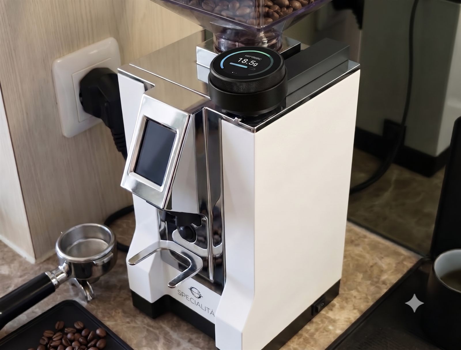 The Crown digital grind dial fitted on a white Eureka Mignon Specialità grinder, its display lit on the counter